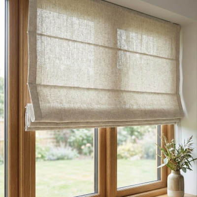 Natural linen roman blind in beige shade mounted on the wooden window frame
