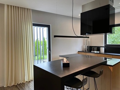 A modern living room with black curtians and black voile curtains